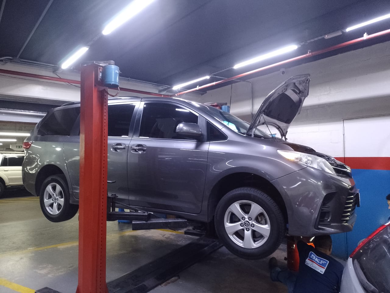 Toyota Sienna com capô aberto no elevador